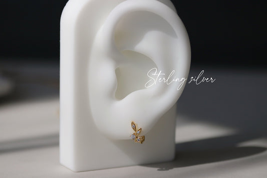 Shan&Co’s Gold Vermeil/Sterling Silver Leaf Cartilage Hoop Earrings, featuring olive leaf designs, perfect for cartilage and helix piercings. Crafted from high-quality gold vermeil or sterling silver, these hoops add an elegant, nature-inspired touch to your jewelry collection.