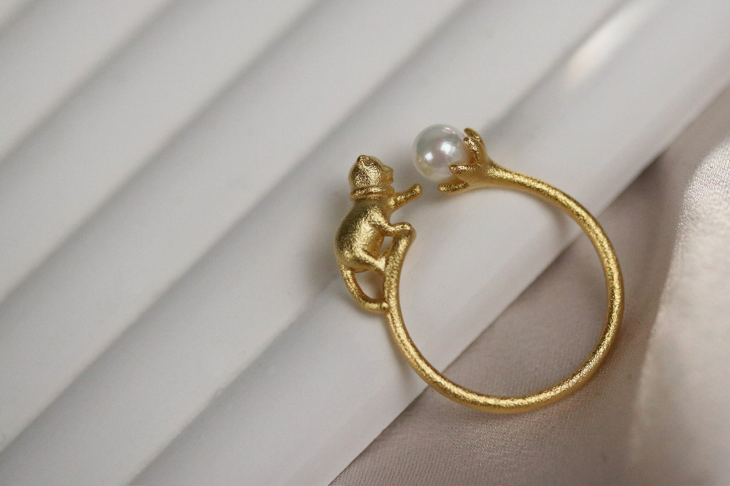 Gold Vermeil Cat Pearl Open Statement Ring featuring a playful cat design that wraps around the finger, adorned with a natural pearl. Adjustable for comfort, this unique piece adds charm and sophistication to any outfit.