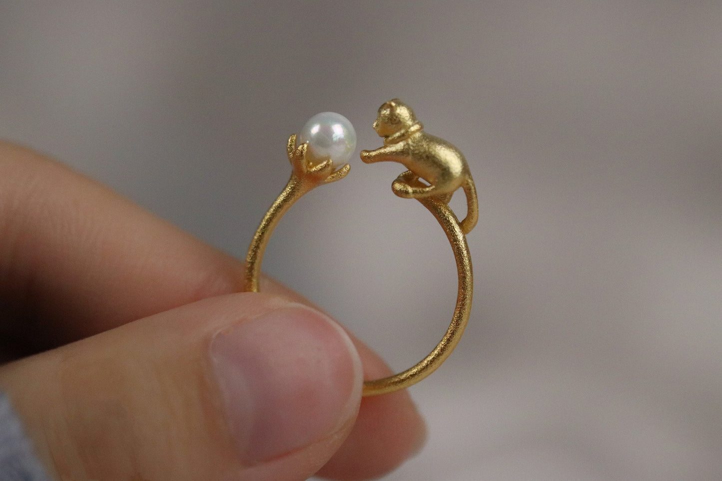 Gold Vermeil Cat Pearl Open Statement Ring featuring a playful cat design that wraps around the finger, adorned with a natural pearl. Adjustable for comfort, this unique piece adds charm and sophistication to any outfit.