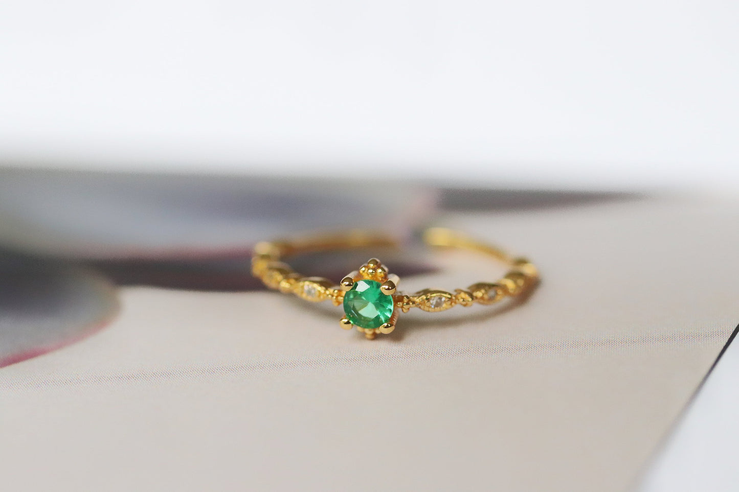 Gold Plated Emerald Ring featuring an adjustable band with a vibrant green cubic zirconia crystal, designed for stacking. A dainty and vintage-inspired piece that blends classic charm with modern versatility.