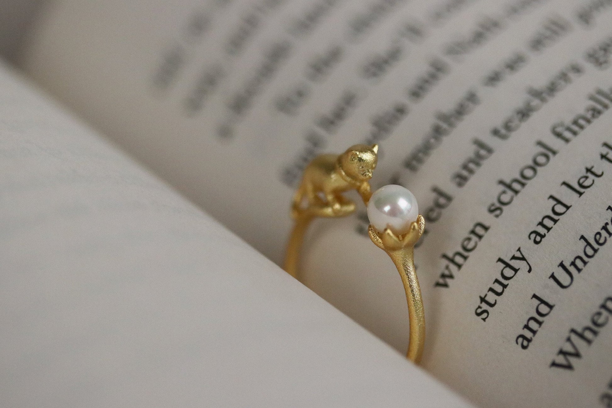 Gold Vermeil Cat Pearl Open Statement Ring featuring a playful cat design that wraps around the finger, adorned with a natural pearl. Adjustable for comfort, this unique piece adds charm and sophistication to any outfit.