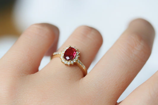 Gold Vermeil Ruby Halo Ring with CZ Accents featuring an elegant oval-cut red gemstone surrounded by a halo of sparkling cubic zirconia. Luxurious and durable, perfect for special occasions or everyday glamour.