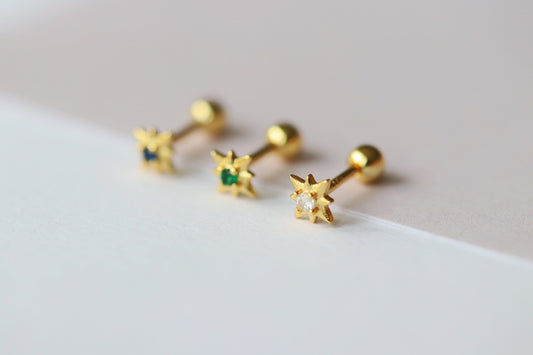 Shan&Co's Gold Starburst Screw Earrings featuring a radiant starburst design with vibrant accents, paired with Star Barbell Earrings for a modern celestial look, crafted in high-quality gold.