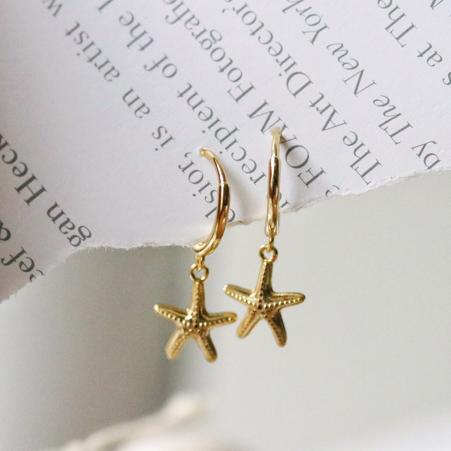 Sterling Silver/Gold Vermeil Starfish Dangle Hoop Earrings featuring a delicate starfish charm hanging from a sleek hoop, available in sterling silver or gold vermeil. These elegant earrings capture the essence of the ocean and add a unique touch to your look. Perfect for beach lovers, these starfish hanging huggies are versatile for both casual and formal occasions.