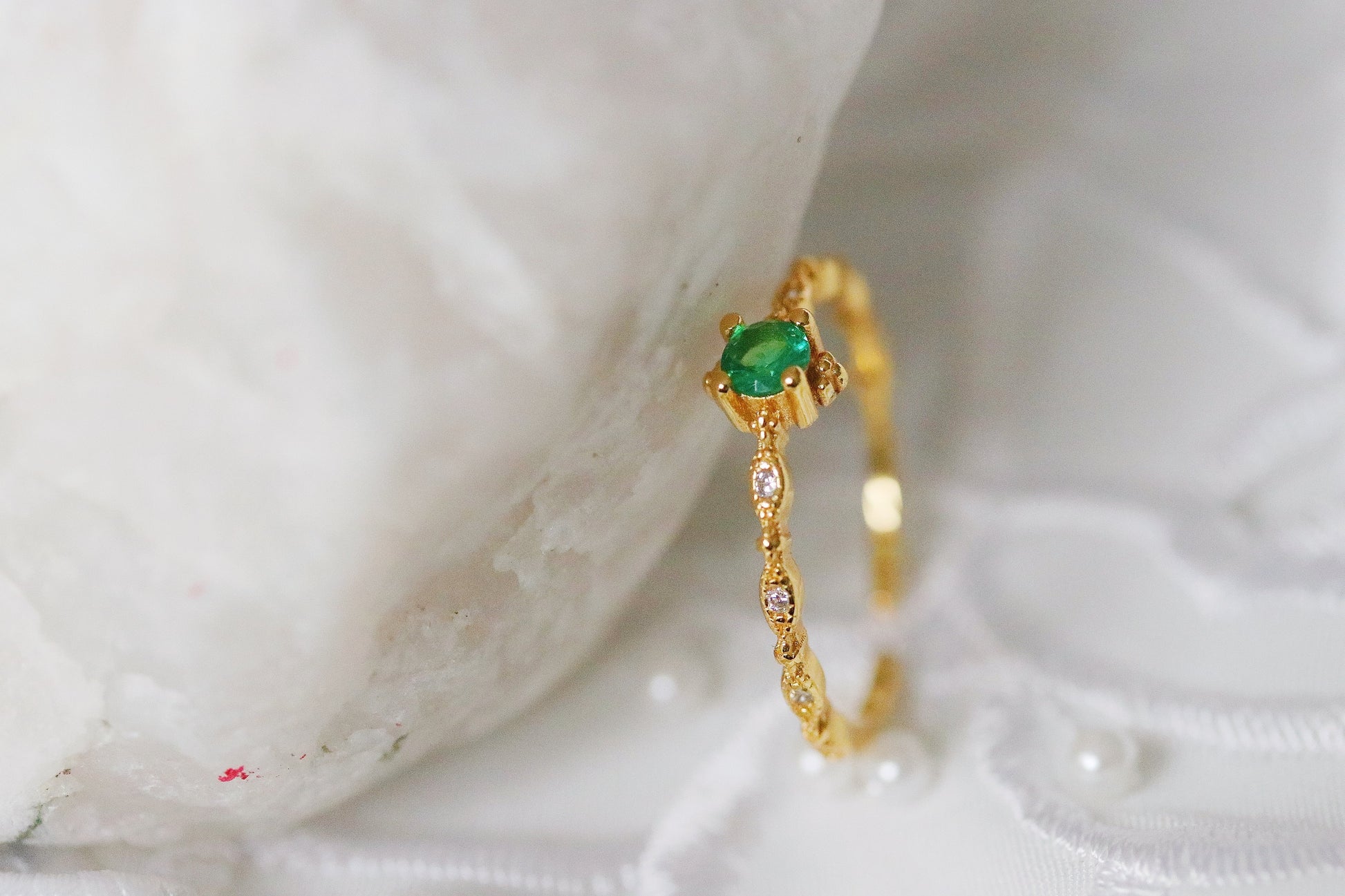 Gold Plated Emerald Ring featuring an adjustable band with a vibrant green cubic zirconia crystal, designed for stacking. A dainty and vintage-inspired piece that blends classic charm with modern versatility.