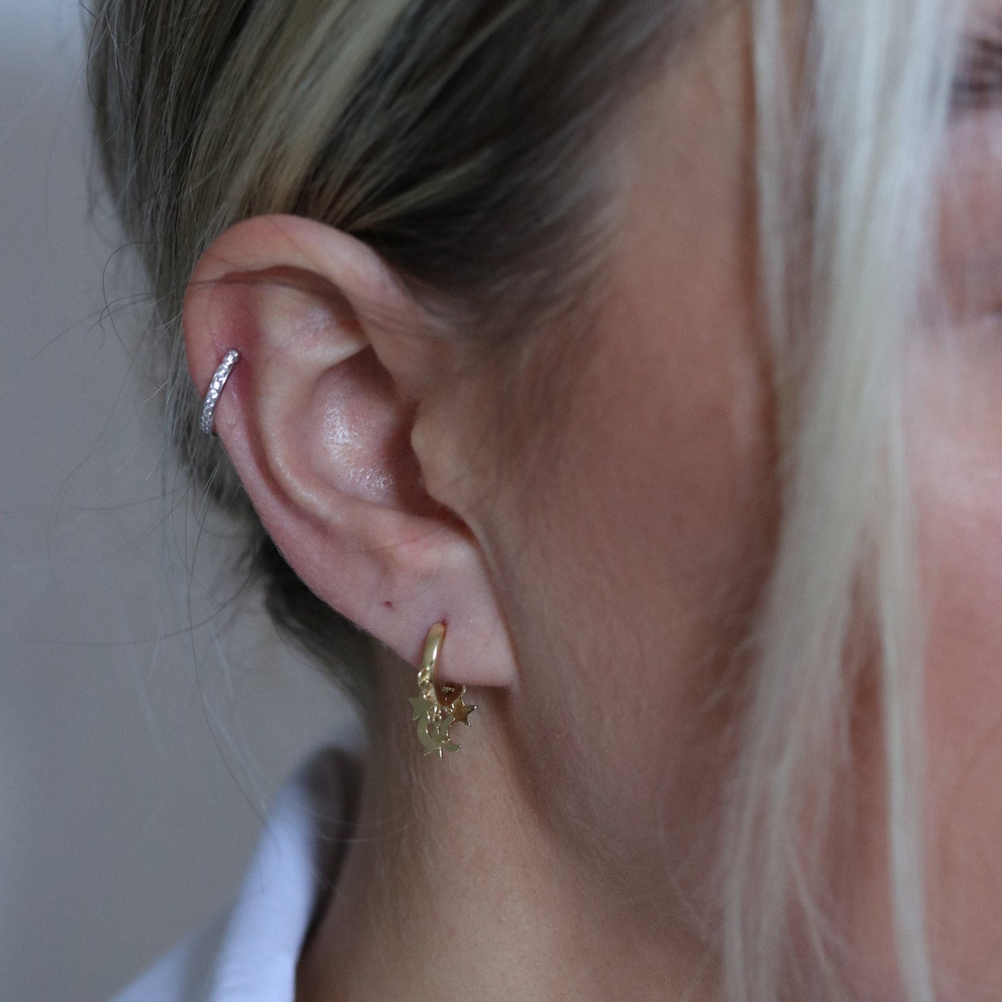 Shan&Co's Gold/Silver Star and Moon Huggies Earrings with delicate star and crescent moon dangle charms, crafted in high-quality gold or silver, perfect for adding a celestial touch to any outfit.