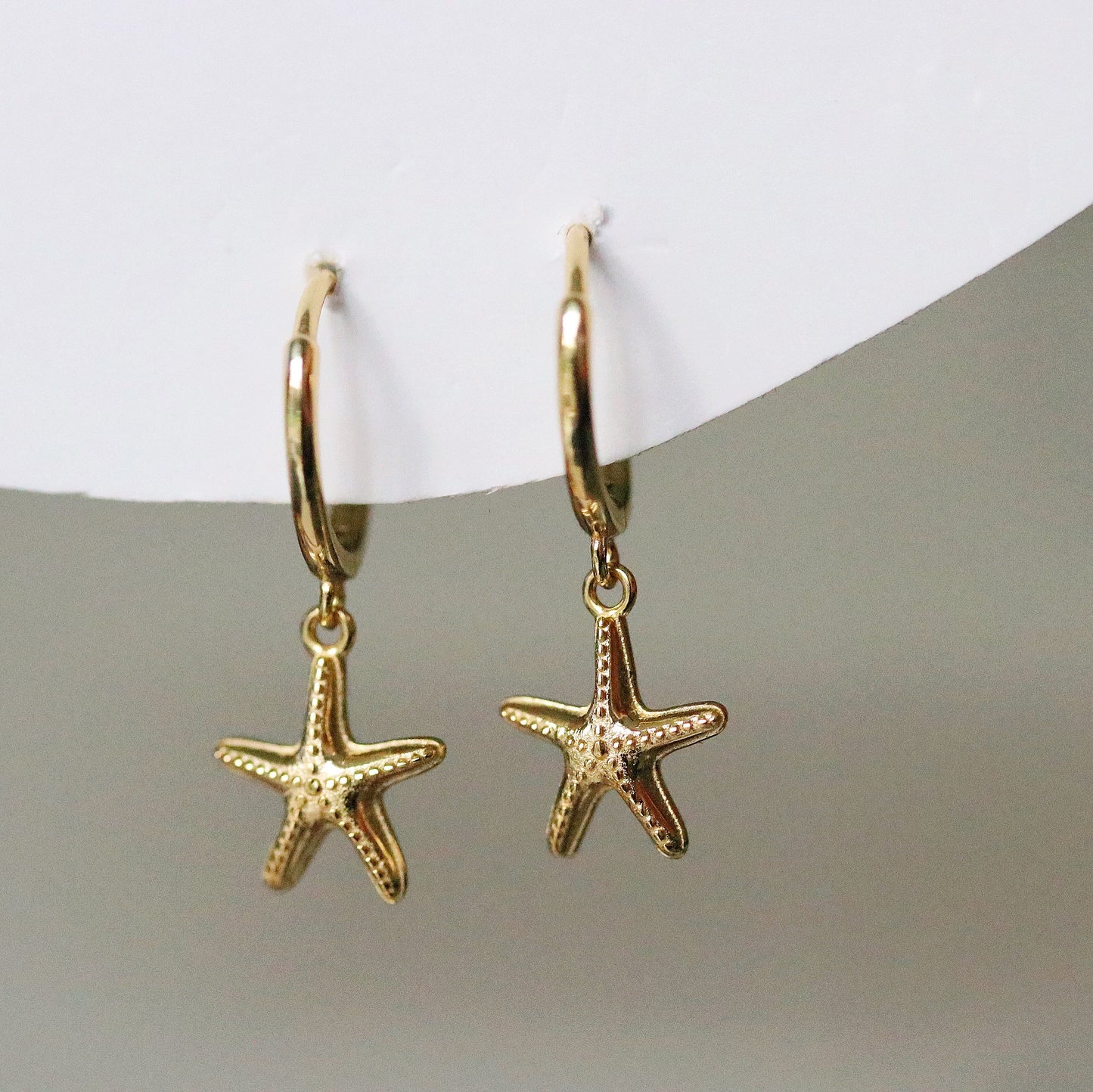 Sterling Silver/Gold Vermeil Starfish Dangle Hoop Earrings featuring a delicate starfish charm hanging from a sleek hoop, available in sterling silver or gold vermeil. These elegant earrings capture the essence of the ocean and add a unique touch to your look. Perfect for beach lovers, these starfish hanging huggies are versatile for both casual and formal occasions.