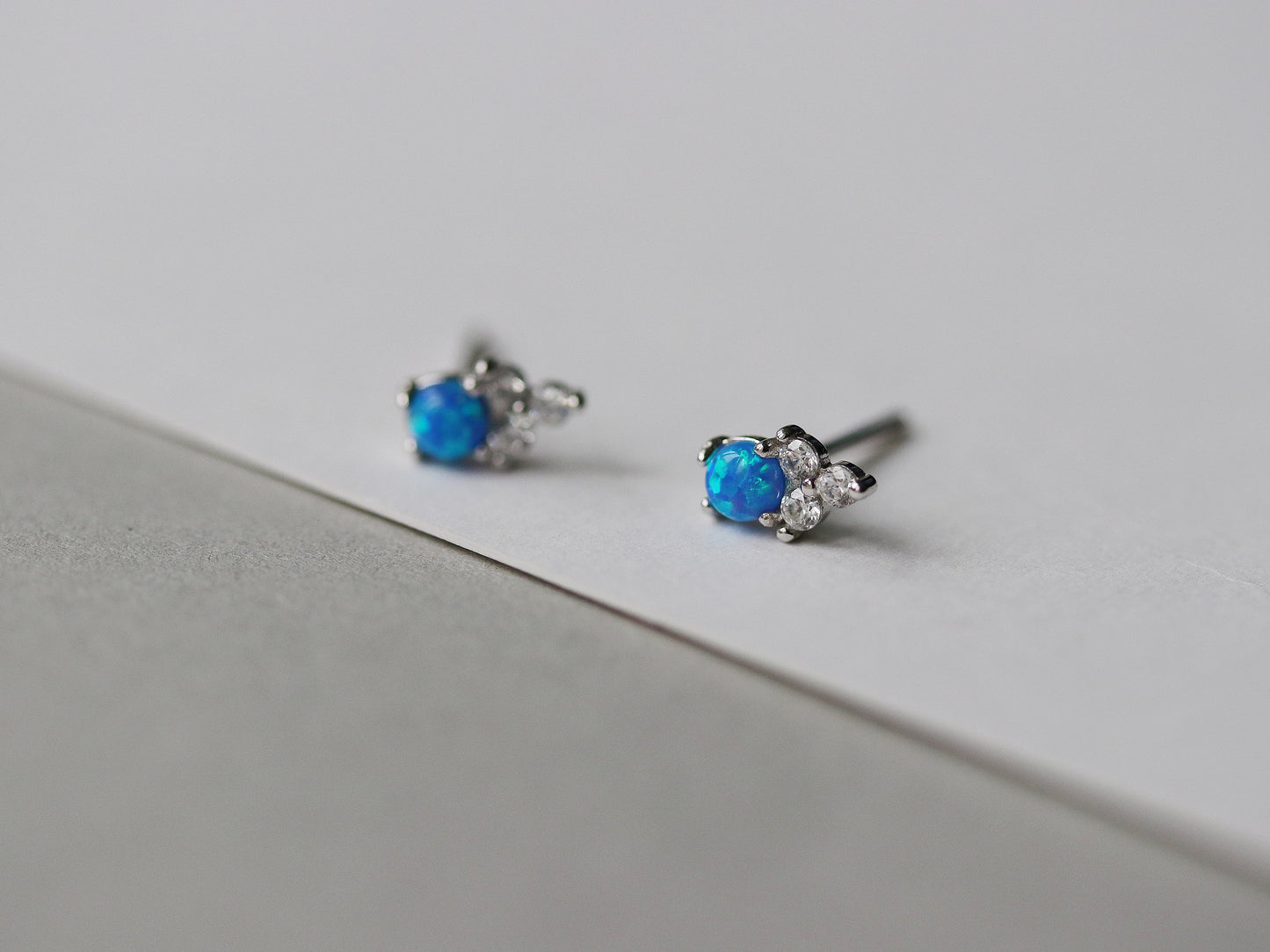 Gold Vermeil/Sterling Silver Opal and Crystal Trio Stud Earrings featuring a dazzling blue opal at the center, accented with sparkling cubic zirconia crystals. These lightweight and elegant earrings offer a luxurious finish, perfect for both casual and special occasions.