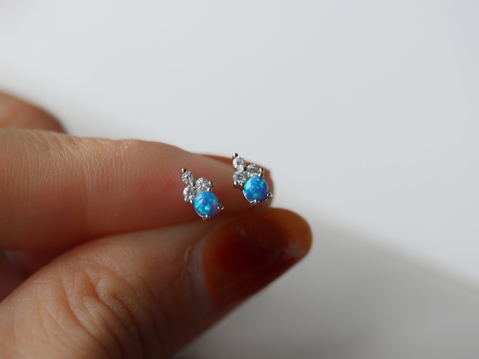 Gold Vermeil/Sterling Silver Opal and Crystal Trio Stud Earrings featuring a dazzling blue opal at the center, accented with sparkling cubic zirconia crystals. These lightweight and elegant earrings offer a luxurious finish, perfect for both casual and special occasions.