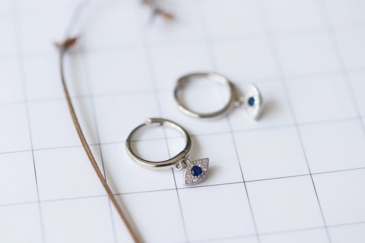 Shan&Co's Gold Vermeil/Sterling Silver Evil Eye Cartilage Hoop Earrings and Eye Huggie Earrings featuring a symbolic evil eye design, available in luxurious gold vermeil or sterling silver for a stylish and protective look.