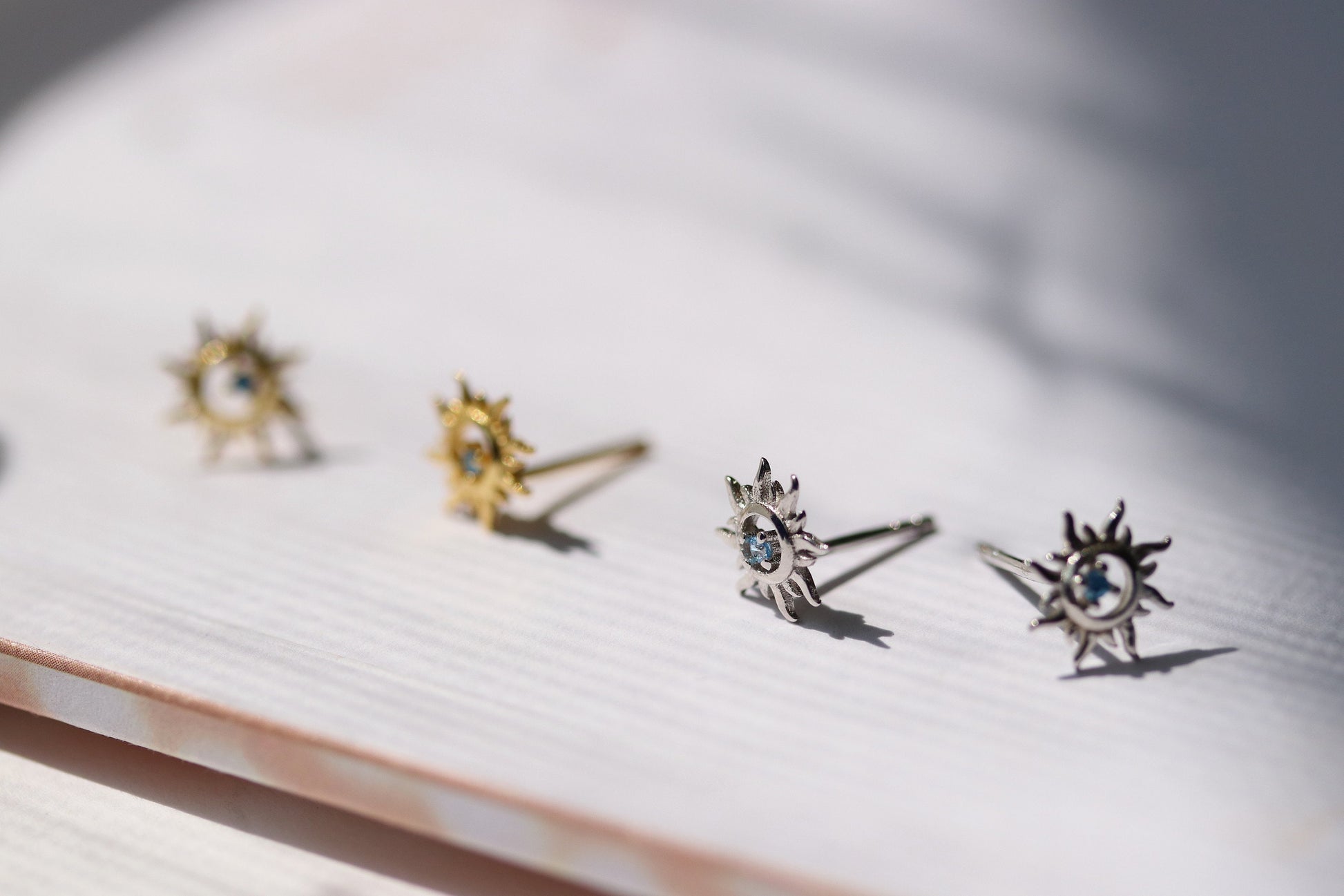 Shan&Co's Sterling Silver/Gold Vermeil Starburst Stud Earrings, featuring a radiant starburst design, paired with Blue Opal Sunburst Studs for a celestial-inspired look. Crafted in high-quality sterling silver or gold vermeil.