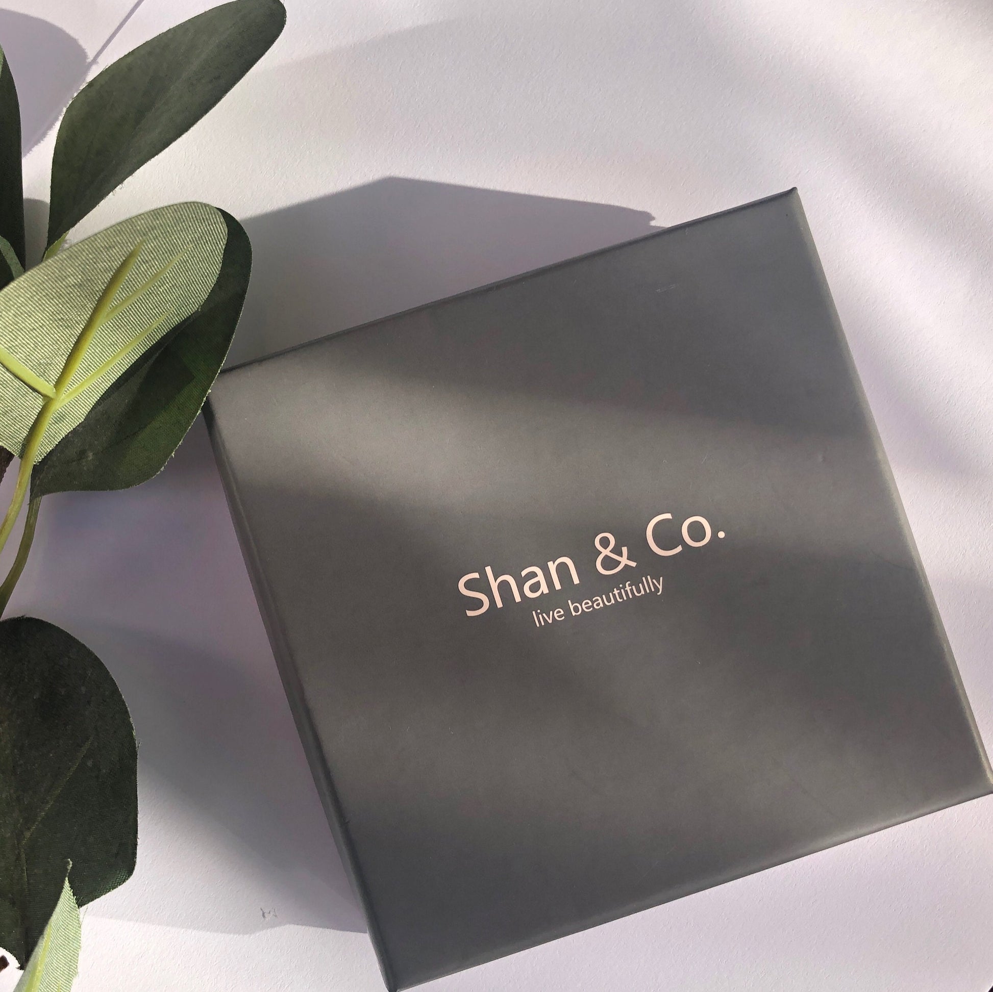 Shan&Co's Sterling Silver/Gold Vermeil CZ Olive Leaf Huggie Earrings, featuring a delicate olive leaf design with sparkling cubic zirconia, perfect for adding a nature-inspired touch of elegance to any outfit.